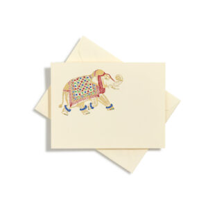 A decorated elephant walks across a cream-colored card, partially covered by an envelope.