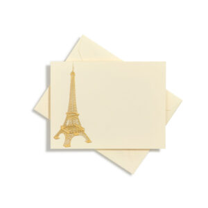 A cream card features a gold illustration of the Eiffel Tower, placed on top of an envelope.
