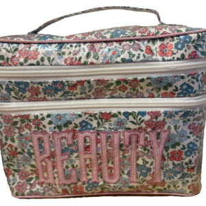 Floral-patterned beauty case with double zippers and "BEAUTY" embroidered on the front.