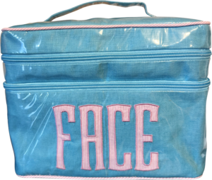 Turquoise double zip bag with pink "FACE" lettering on the front.
