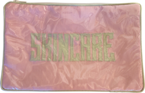 Pink and white cosmetic bag with "SKINCARE" embroidered on the front.