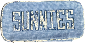 Blue glasses case with "SUNNIES" embroidered, featuring a Liberty print design.