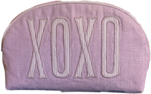Lavender pouch with "XOXO" embroidered in striped white letters.