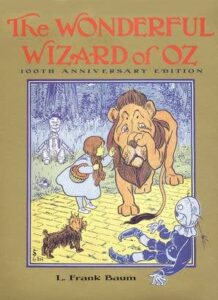 Cover of "The Wonderful Wizard of Oz" featuring Dorothy, the Cowardly Lion, and the Tin Man in a forest.
