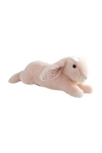 A soft, pink plush bunny with patterned ears lies on its stomach.