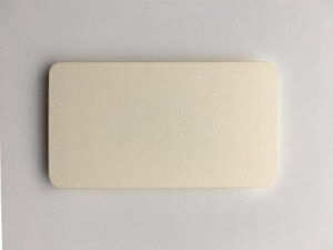 Cream-colored card with a textured surface, placed on a light background.