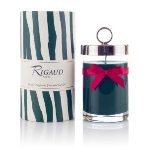 Scented candle in a glass jar with a silver lid and red ribbon, next to a decorative striped box.