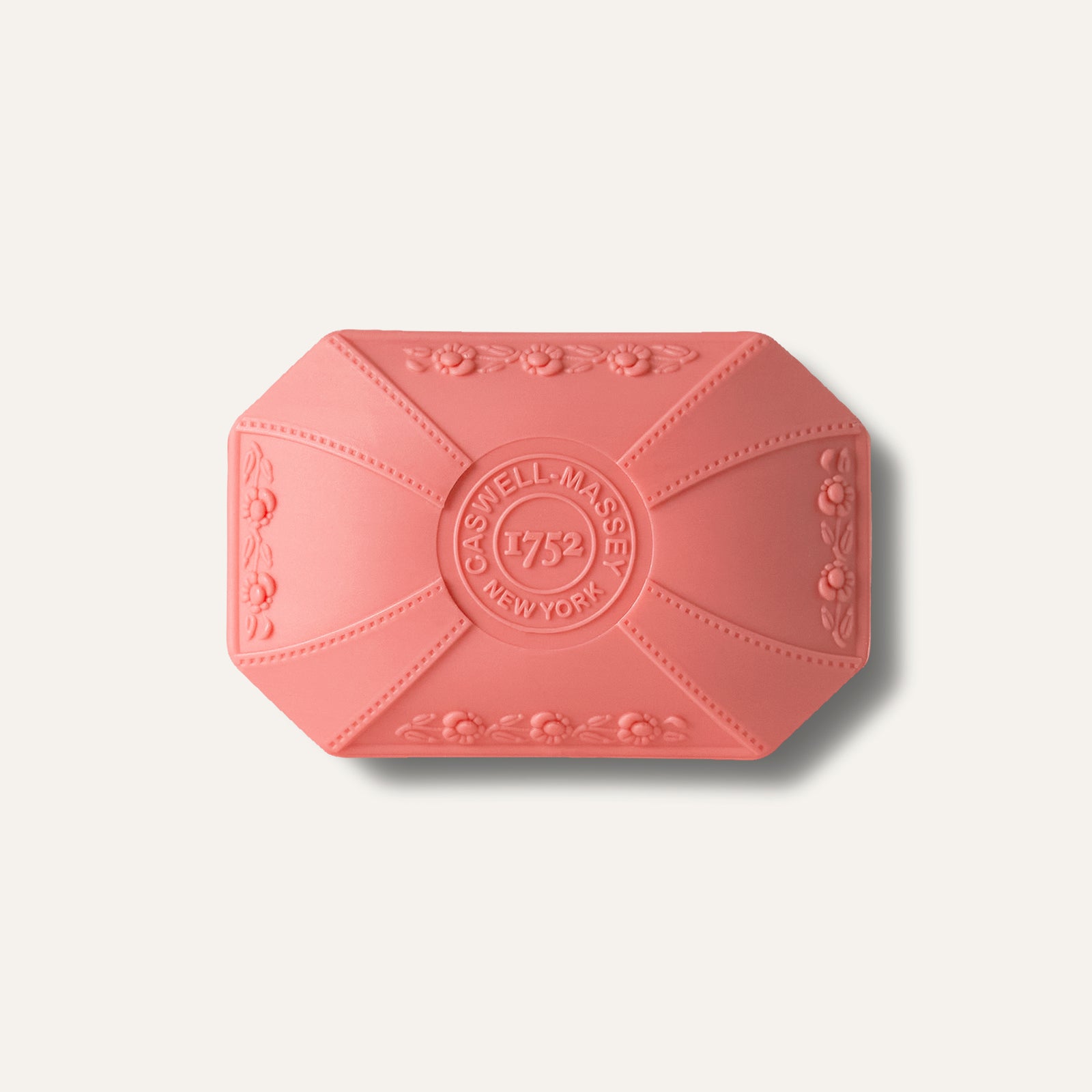 Pink bar soap with floral design and "Caswell-Massey 1752 New York" embossed on the surface.