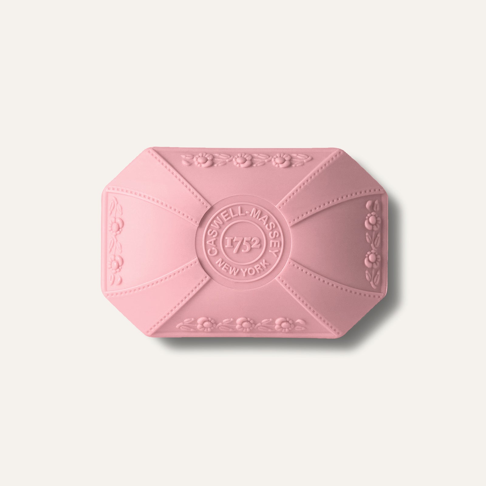 Pink bar soap with floral design and "Caswell-Massey 1752 New York" embossed on the surface.