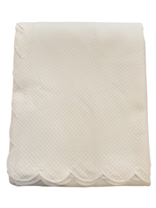 Ivory matelassé queen blanket with a scalloped edge, folded neatly.