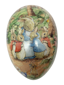 A large egg features Beatrix Potter's rabbits in colorful clothing, gathered around a central rabbit.