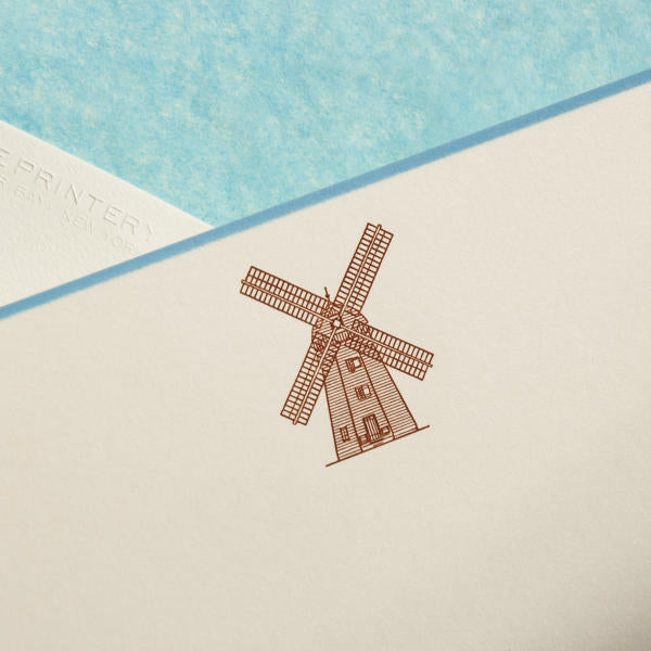 A brown illustration of a windmill on a cream-colored card with a blue background.