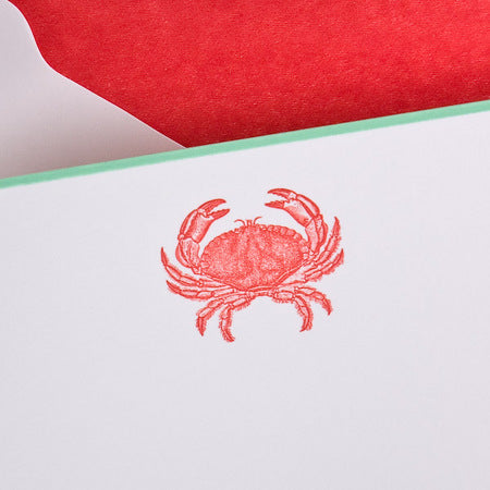 A red crab illustration is centered on a white note card with a green border.