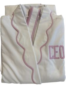 White robe with pink scalloped trim and "CEO" embroidered on the front.