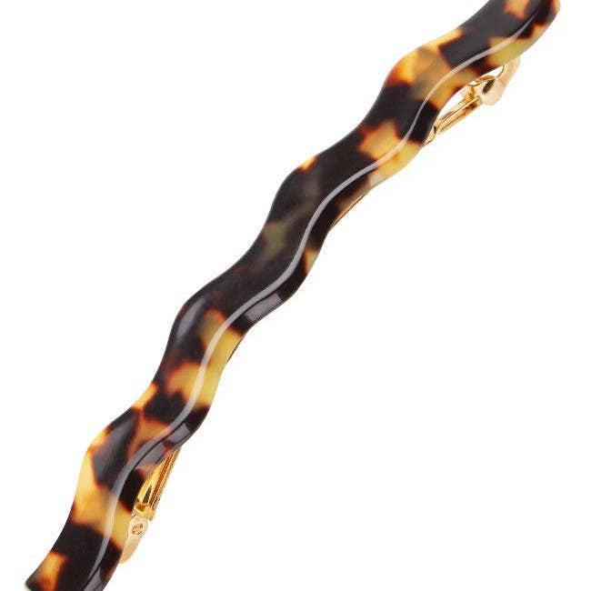 A wavy hair clip in tortoiseshell pattern with a gold clasp.