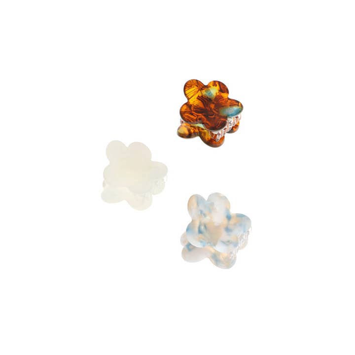 Three flower-shaped objects in varying colors: amber, translucent white, and light blue.