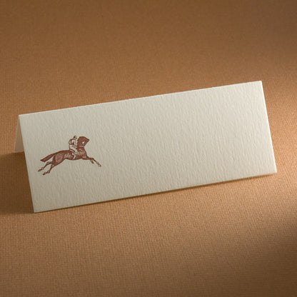 A folded place card with a brown illustration of a horse and rider on a textured cream background.