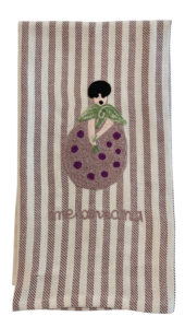 Kitchen towel featuring an embroidered eggplant with a character holding a leaf and the word "melanzana.