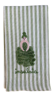 A green and white striped kitchen towel features an embroidered figure resembling a salad.