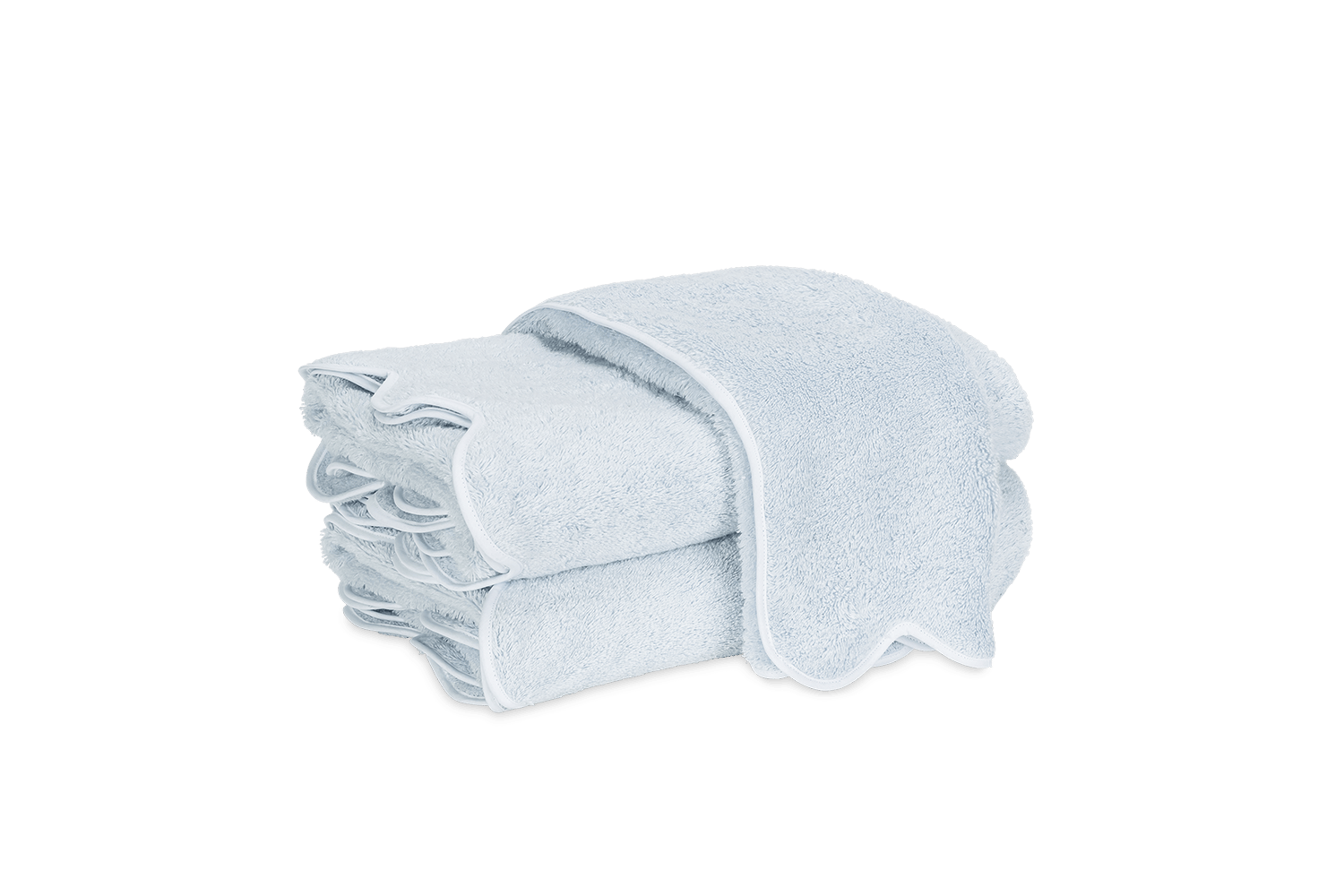 Stack of light blue towels with scalloped edges, neatly folded on a green background.