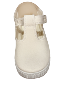 White T-strap sneaker with a textured sole and adjustable strap.
