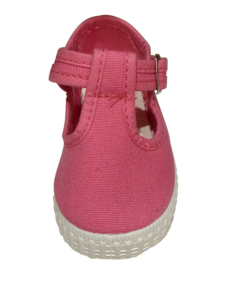 Fuchsia T-strap sneaker with a white sole, showing the front view and strap detail.