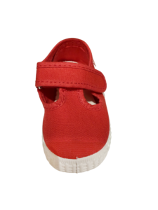 Red T-strap sneaker with white sole, featuring cut-out details and adjustable strap.