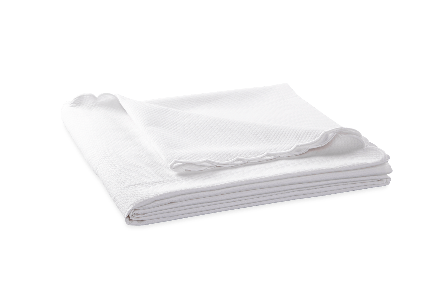 White coverlet folded neatly, featuring a textured pattern and scalloped edges.