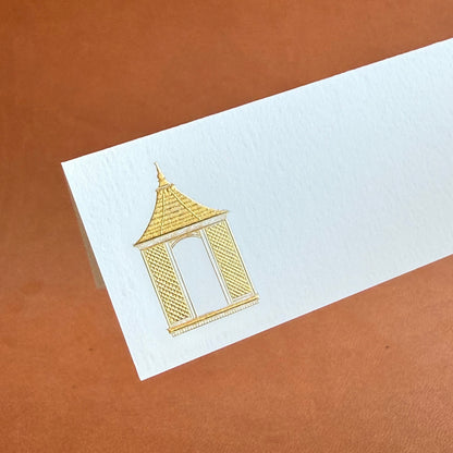 A detailed illustration of a golden dovecote on a white card against a brown background.