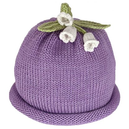 Purple knitted hat with white lily flowers and green leaves on top.
