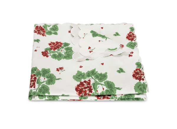 Scarlet geranium-patterned duvet cover folded with a scalloped edge and green leaves.