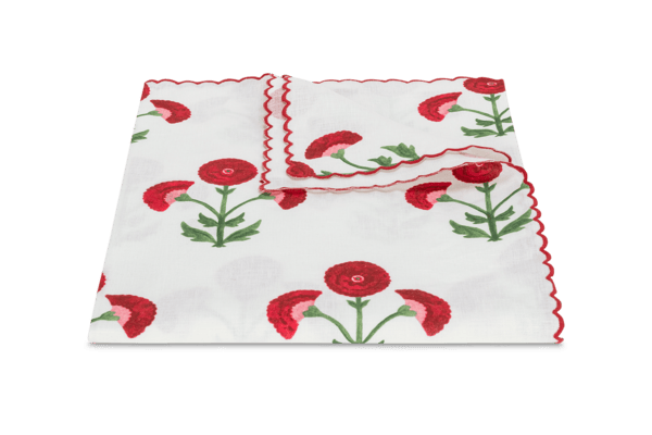 White tablecloth with red flowers and green stems, featuring a scalloped edge.
