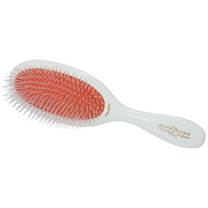 A white detangling brush with a textured orange bristle pad and a curved handle.