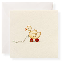 A wooden duck toy on wheels, pulled by a string, against a light background with an envelope.