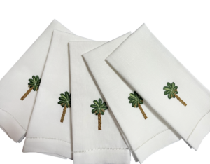 Five white guest towels with embroidered palm trees arranged neatly.