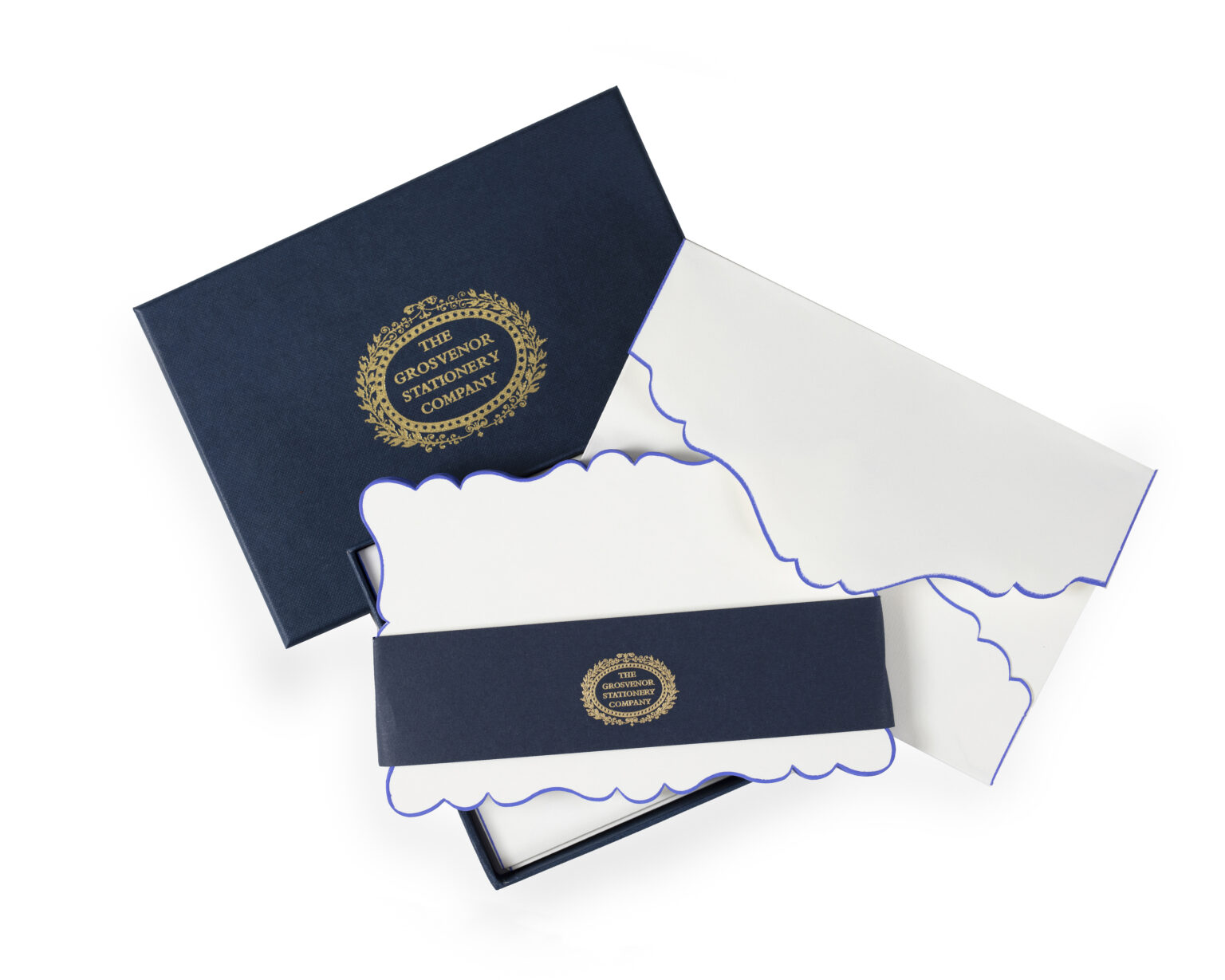 A navy box contains white stationery with scalloped edges and a decorative band.