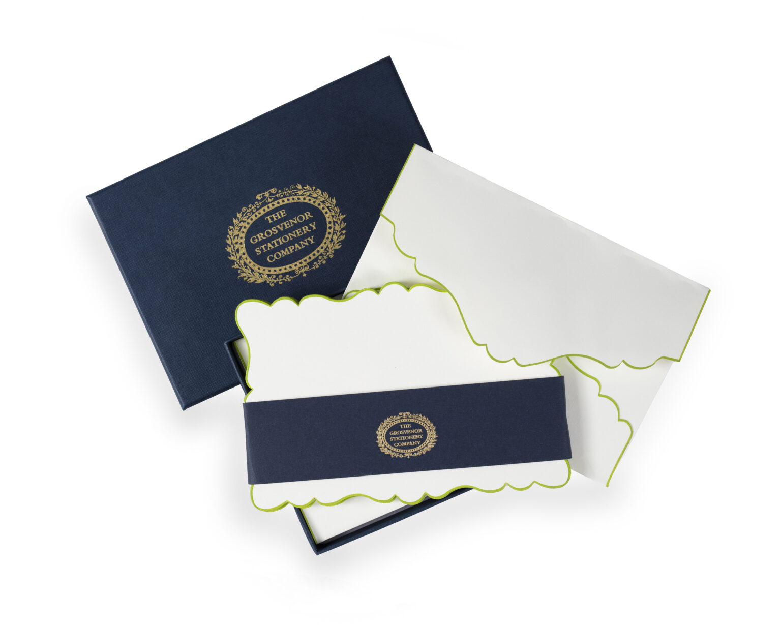 A navy box contains scalloped-edge stationery with a green trim and a decorative band.