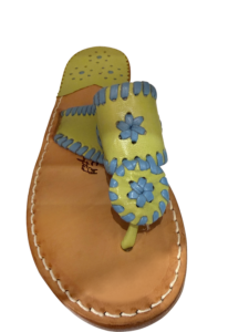 Colorful sandal with a yellow strap featuring blue flowers and a tan sole.