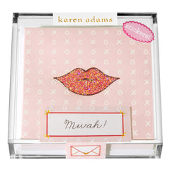 A clear box contains pink stationery with a glittery lip design and the word "Mwah!" on it.